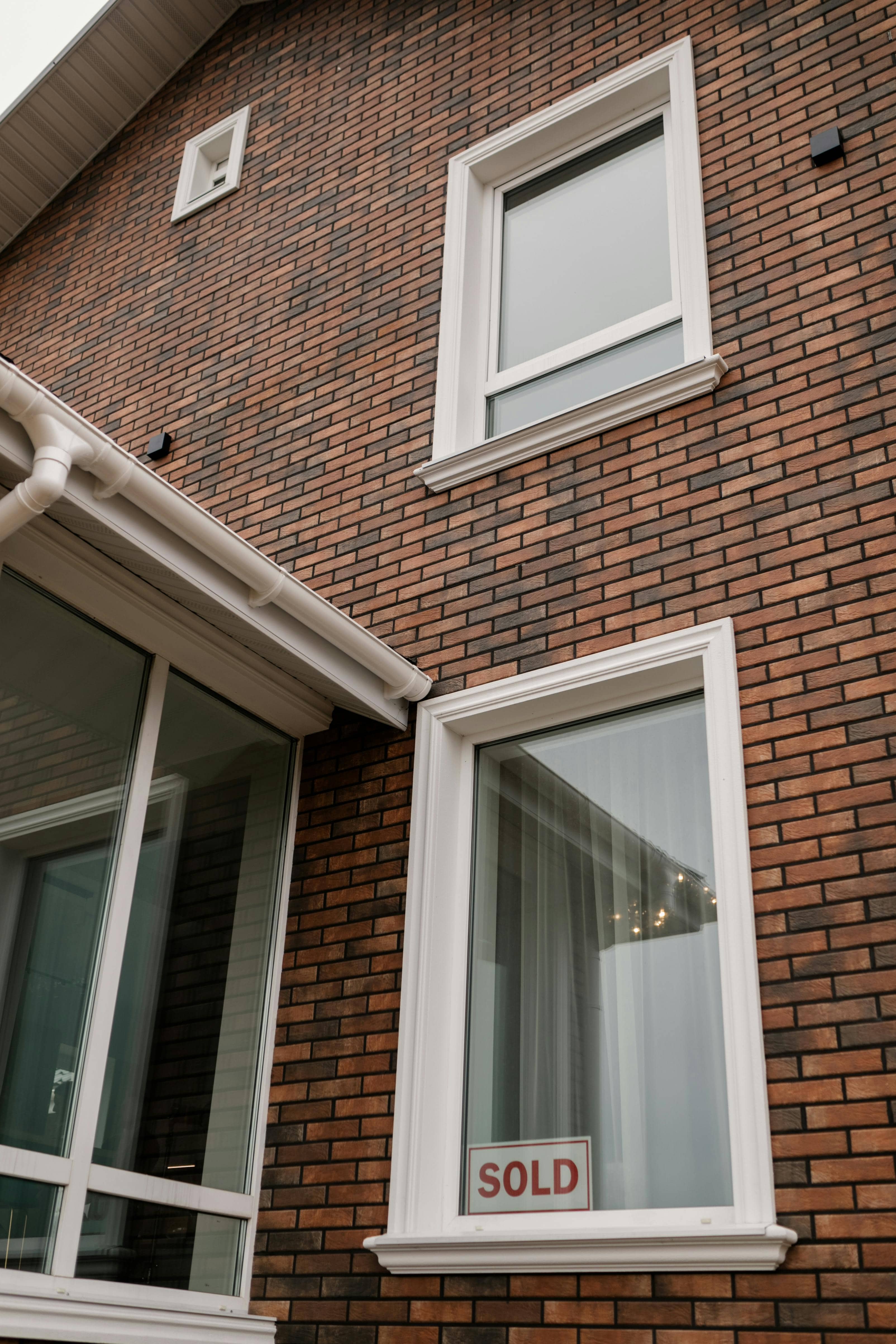Solgt-skilt i vindu på moderne bolig